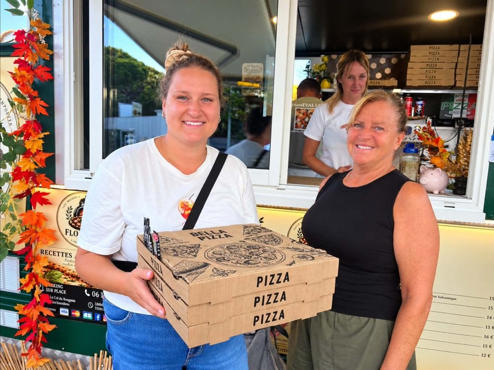 Deux clientes repartent du camion Flo Pizza avec trois bo&icirc;tes de pizza