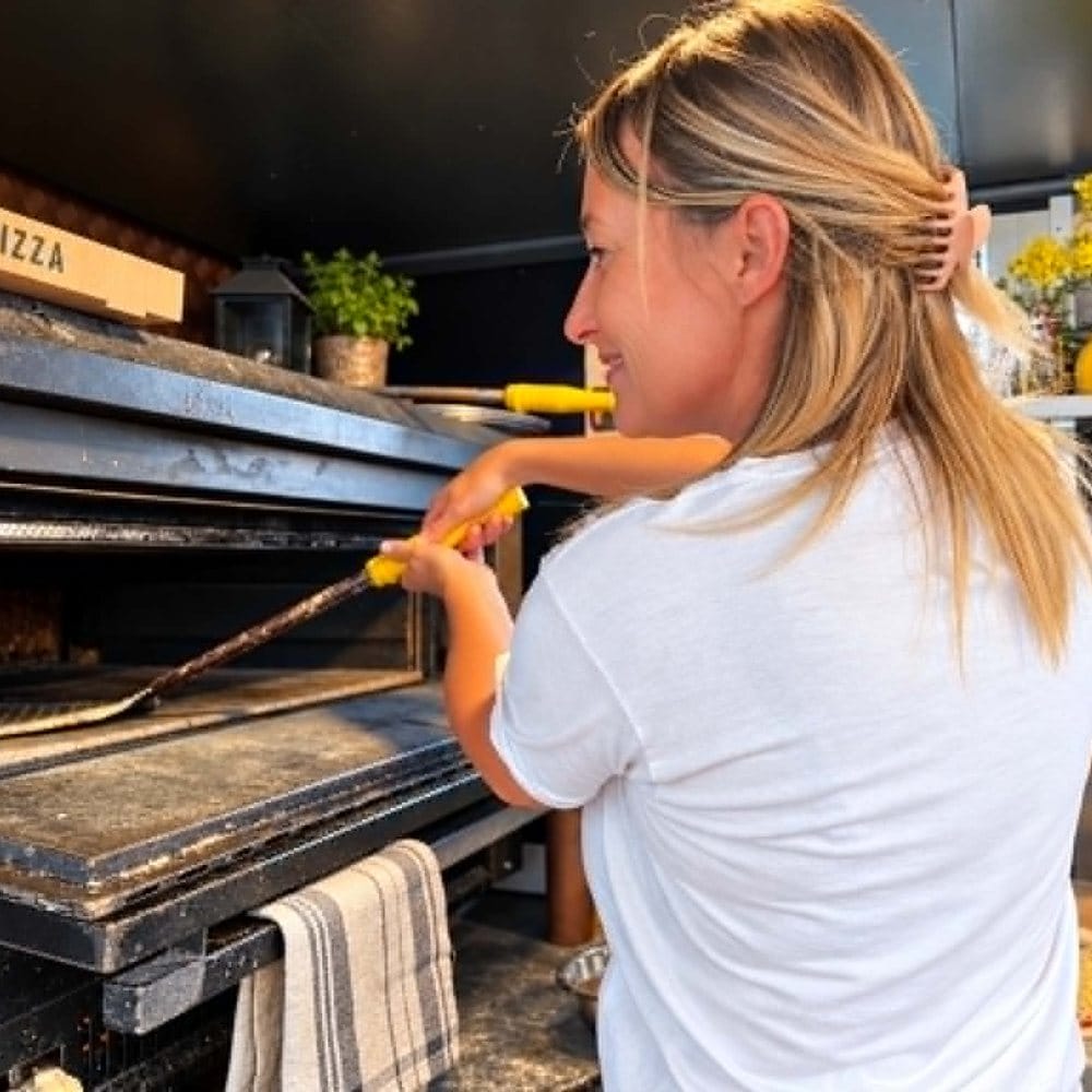 Flo enfourne une pizza &agrave; la pelle dans le four du camion